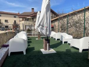 a row of white chairs sitting on the grass at Hotel Rural Milaleku in Ecala