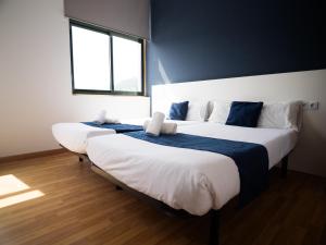 two beds in a room with two windows at Bahía de San Simón in Redondela +6 photos