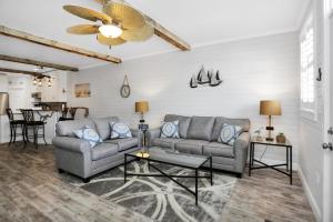 a living room with two couches and a ceiling fan at Set Sail at 5 by Pristine Properties Vacation Rentals in Mexico Beach +23 photos
