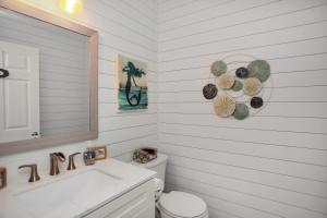 a bathroom with a toilet and a sink and a mirror at Set Sail at 5 by Pristine Properties Vacation Rentals in Mexico Beach