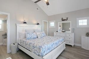 a white bedroom with a bed and a mirror at Second Chance by Pristine Properties Vacation Rentals in Mexico Beach