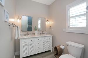 a white bathroom with two sinks and a toilet at Second Chance by Pristine Properties Vacation Rentals in Mexico Beach +43 photos