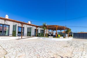 a building with a pavilion on a stone patio at As Praias in Sesimbra