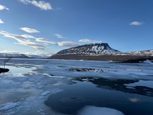 a body of water with a mountain in the background at Kilpis-Silent Apartment in Kilpisjärvi