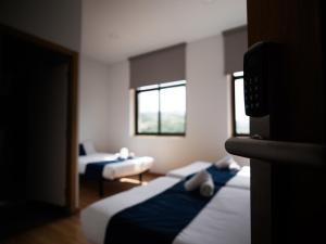 a hotel room with two beds and two windows at Bahía de San Simón in Redondela
