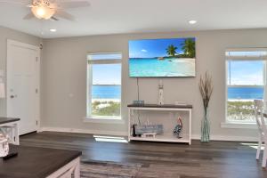 a living room with a flat screen tv on the wall at Pelican Roost A by Pristine Properties Vacation Rentals in Mexico Beach
