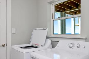 a white washing machine in a bathroom with a window at Pelican Roost A by Pristine Properties Vacation Rentals in Mexico Beach +38 photos