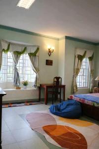 a bedroom with a bed and a table and windows at Perla Home in Danang