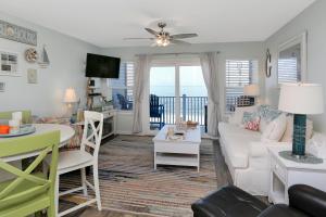 a living room with a white couch and a table at Sandcastle C by Pristine Properties Vacation Rentals in Mexico Beach
