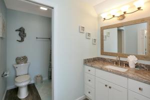 a bathroom with a toilet and a sink and a mirror at Sandcastle C by Pristine Properties Vacation Rentals in Mexico Beach +27 photos