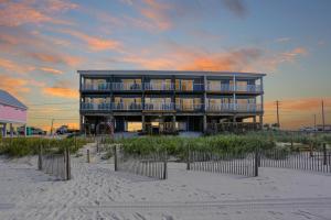 a building on the beach with a sunset at Sandcastle C by Pristine Properties Vacation Rentals in Mexico Beach