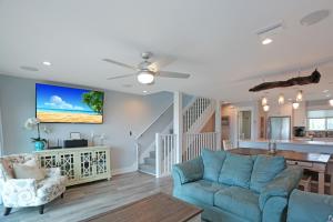 a living room with a blue couch and a staircase at Sharla's Sunrise by Pristine Properties Vacation Rentals in Indian Pass