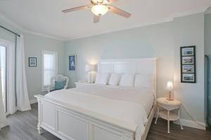 a white bedroom with a white bed and a ceiling fan at Paradise Shores 302 Serenity Shores by Pristine Properties Vacation Rentals in Mexico Beach