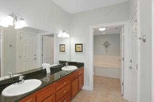 a bathroom with two sinks and a large mirror at Paradise Shores 302 Serenity Shores by Pristine Properties Vacation Rentals in Mexico Beach +27 photos