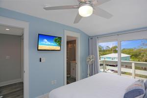 a bedroom with a bed and a tv on the wall at Sharla's Sunrise by Pristine Properties Vacation Rentals in Indian Pass