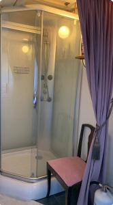 a shower with a chair and a shower curtain at Ateljé Sjögatan in Gränna