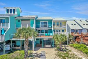 a row of houses on the beach with palm trees at Sharla's Sunrise by Pristine Properties Vacation Rentals in Indian Pass