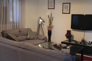 a living room with a couch and a tv at Salt Lake Town House in Larnaca