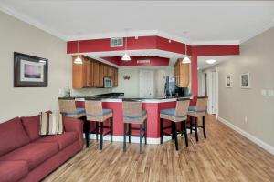 a kitchen and living room with a couch and a bar at Paradise Shores 310 by Pristine Properties Vacation Rentals in Mexico Beach
