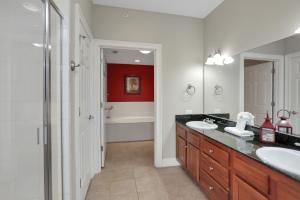a bathroom with two sinks and a red wall at Paradise Shores 310 by Pristine Properties Vacation Rentals in Mexico Beach +24 photos