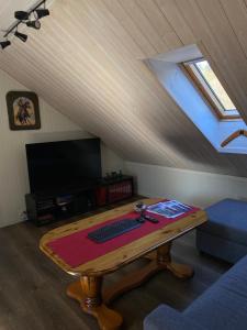 a living room with a wooden table with a keyboard at Leilighet toppetasje, Flekkefjord in Flekkefjord