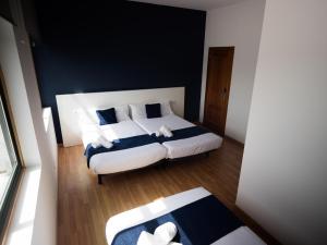 a bedroom with two beds with blue and white pillows at Bahía de San Simón in Redondela