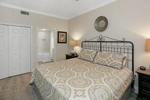 a bedroom with a bed and a clock on the wall at Summerhouse 209 by Pristine Properties Vacation Rentals in Mexico Beach +32 photos
