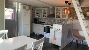 a kitchen with a white refrigerator and a table at Ateljé Sjögatan in Gränna +3 photos