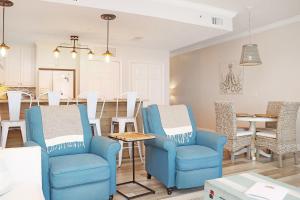 a living room with two blue chairs and a table at Summerhouse 309 by Pristine Properties in Mexico Beach