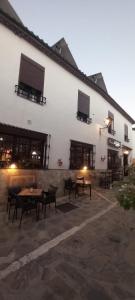 a building with tables and chairs in a courtyard at Hotel Rural Inz-Almaraz in Jimera de Líbar