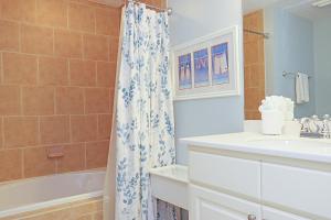 a bathroom with a sink and a shower curtain at Summerhouse 309 by Pristine Properties in Mexico Beach +43 photos
