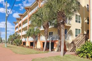 a building with palm trees in front of it at Summerhouse 309 by Pristine Properties in Mexico Beach