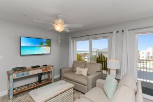 a living room with a couch and a tv at Surfside 15 - Beachtime by Pristine Properties Vacation Rentals in Mexico Beach