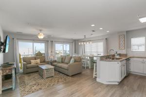 a kitchen and living room with a couch and a table at Surfside 15 - Beachtime by Pristine Properties Vacation Rentals in Mexico Beach