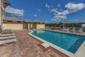 a swimming pool with chairs in front of a building at Summerhouse 203 by Pristine Properties Vacation Rentals in Mexico Beach
