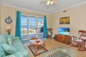 a living room with a blue couch and a tv at Summerhouse 203 by Pristine Properties Vacation Rentals in Mexico Beach