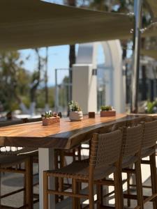ein Holztisch mit Stühlen und Topfpflanzen darauf in der Unterkunft Hotel Santorini in Fira