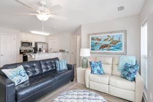 a living room with a black leather couch and a white couch at Surfside 17 by Pristine Properties Vacation Rentals in Mexico Beach