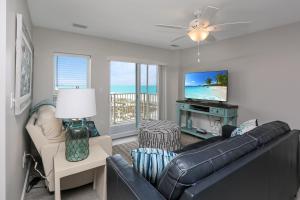 a living room with a couch and a tv at Surfside 17 by Pristine Properties Vacation Rentals in Mexico Beach