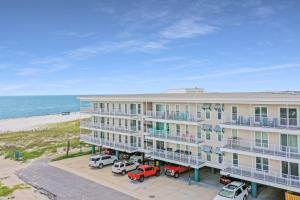 an apartment building with cars parked in front of the beach at Surfside 17 by Pristine Properties Vacation Rentals in Mexico Beach