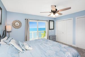 a blue bedroom with a bed and a ceiling fan at Beach Therapy by Pristine Properties Vacation Rentals in Cape San Blas