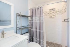 a bathroom with a shower curtain and a toilet at Beach Therapy by Pristine Properties Vacation Rentals in Cape San Blas +43 photos