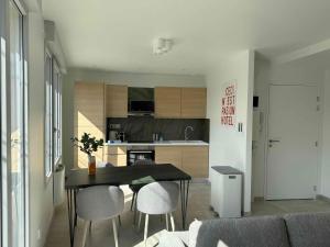 a kitchen and dining room with a table and chairs at La Bergerie 3 in Neufchâteau