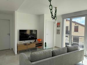 a living room with a couch and a flat screen tv at La Bergerie 3 in Neufchâteau