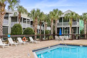 a resort with a swimming pool and palm trees at Barefoot Cottage B37 by Pristine Properties in Highland View