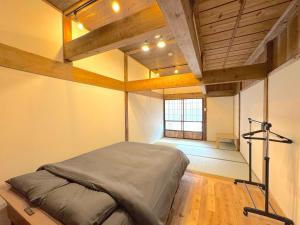 a bedroom with a bed in a room with a window at Ango KIKAIJIMA in Onozu