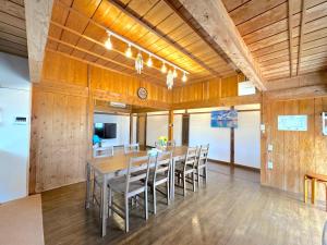 a dining room with a long table and chairs at Ango KIKAIJIMA in Onozu