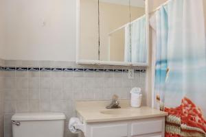 a bathroom with a sink and a toilet and a mirror at Amethyst Dunes by Pristine Properties Vacation Rentals in Indian Pass +101 photos