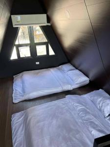 a bedroom with two beds and a window at Romantic A-Frame Cabin w/ a View + WiFi in Samal