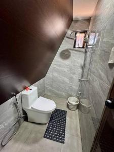a small bathroom with a toilet and a shower at Romantic A-Frame Cabin w/ a View + WiFi in Samal